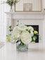 White real touch rose peony hydrangea centerpiece in a glass vase styled on a mantel