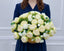 White and green ombre peony centerpiece held by a floral designer