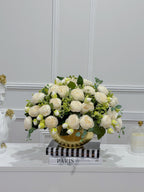 White peony centerpiece in gold vase styled with books