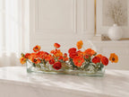 Orange ranunculus poppy daisy fall centerpiece in a clear glass vase