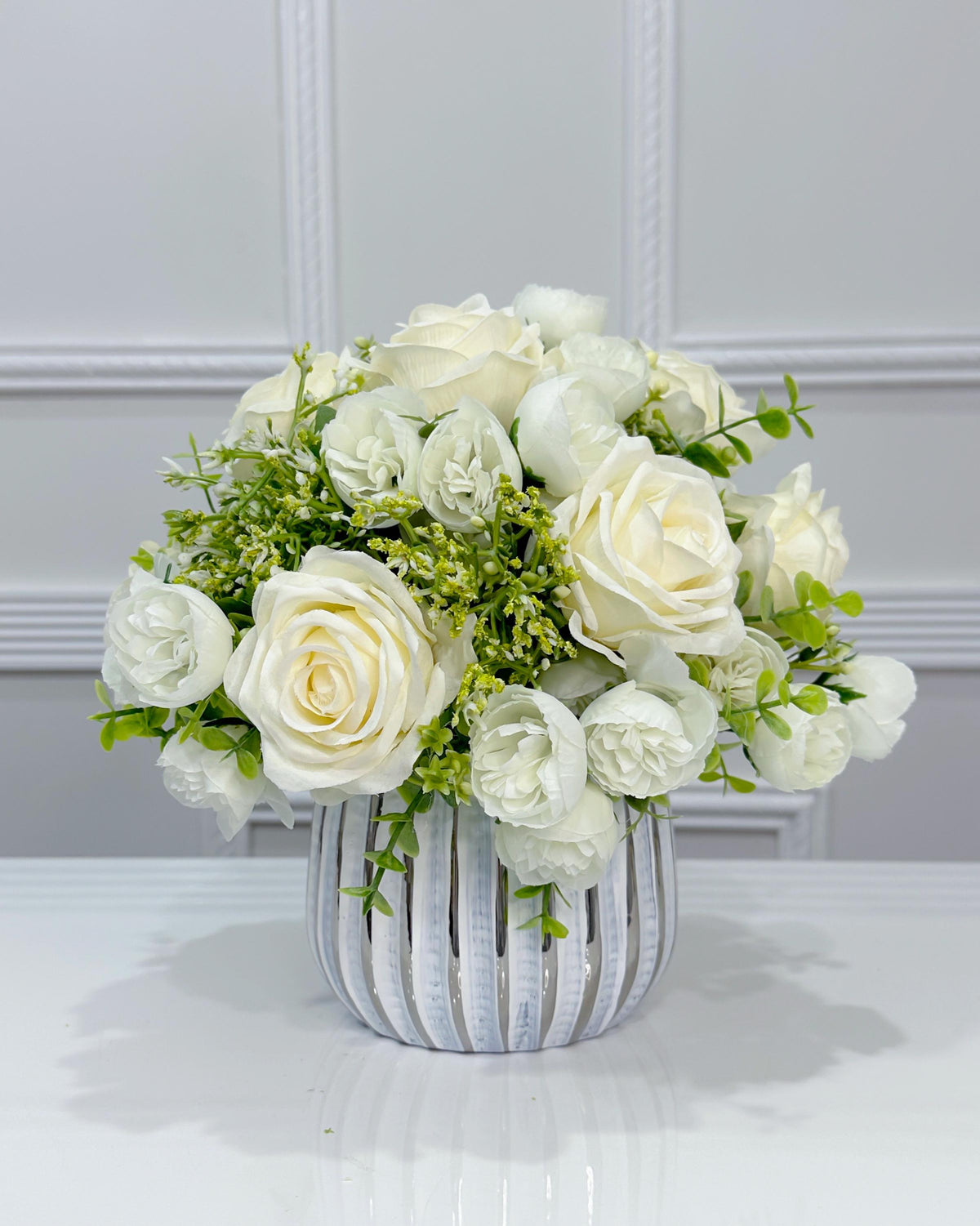 White silk rose and peony faux floral centerpiece in a ribbed vase