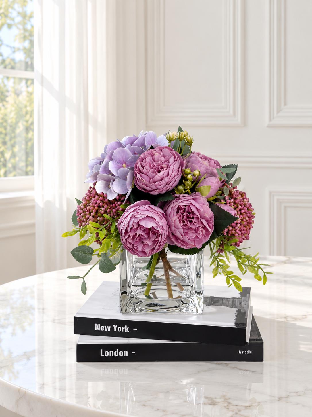 Purple peony rose and hydrangea faux floral centerpiece in a clear glass vase