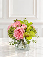 Pink and green real touch rose and orchid faux floral centerpiece in a glass vase