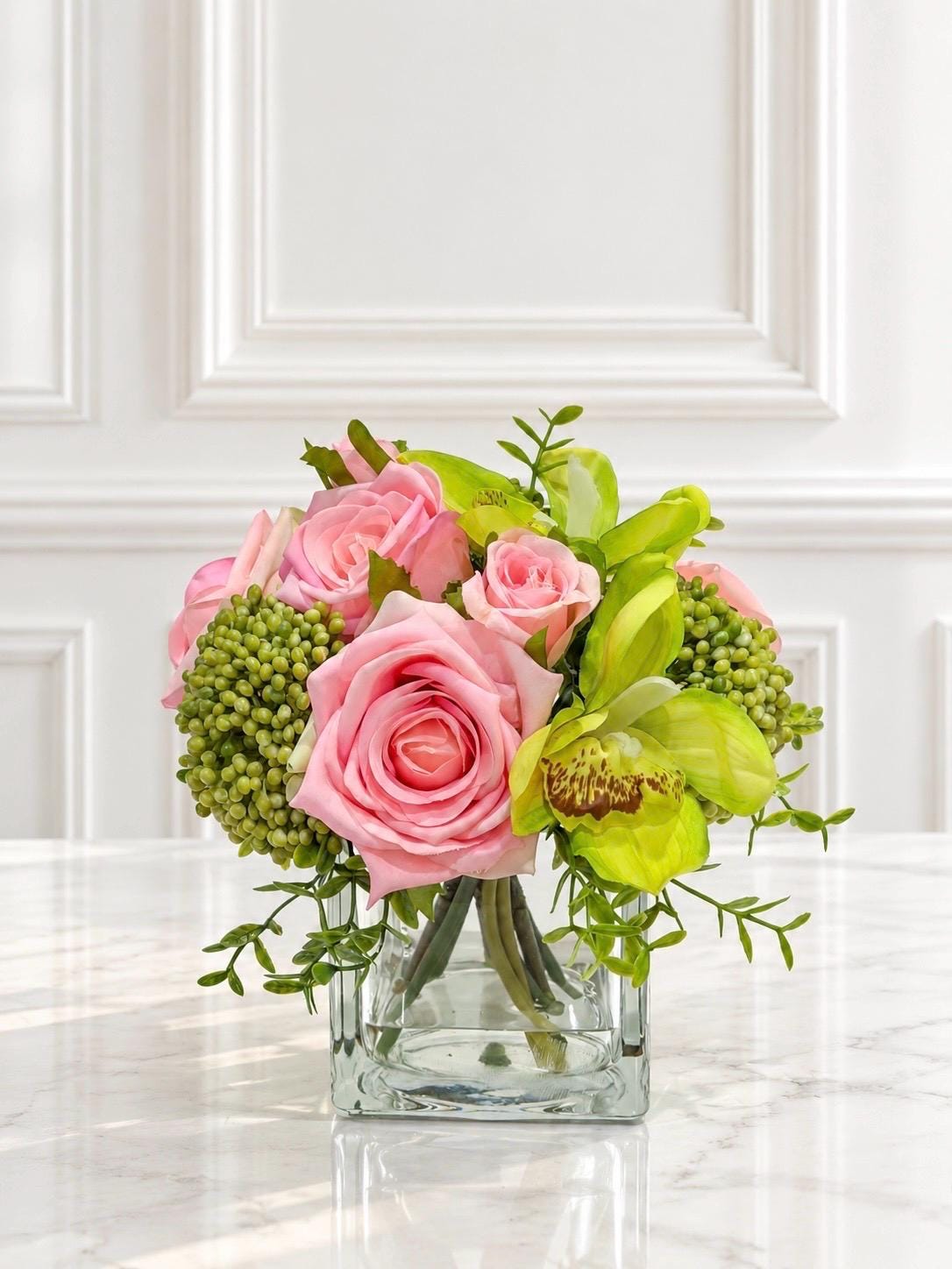 Pink and green real touch rose and orchid faux floral centerpiece in a glass vase