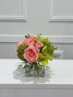 Pink and green real touch rose and orchid faux floral centerpiece in a glass vase