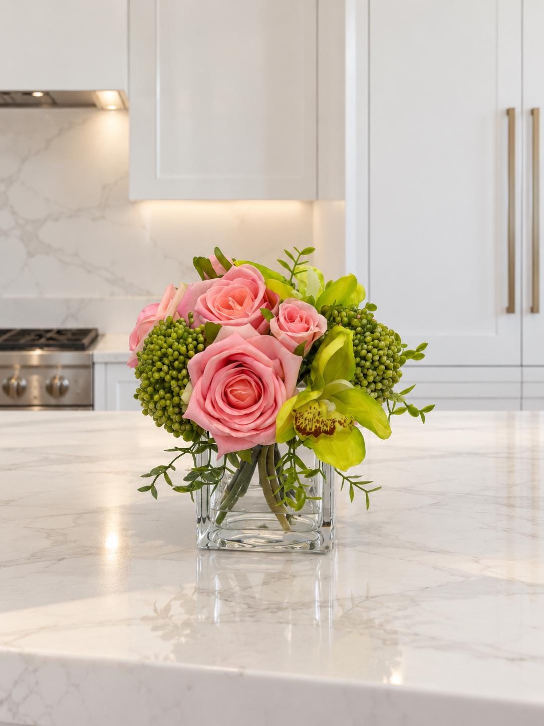 Pink and green real touch rose and orchid faux floral centerpiece in a glass vase