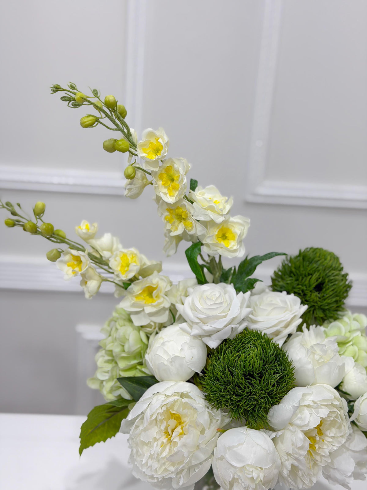 Ivory snapdragons and white blooms in a European contemporary faux floral design