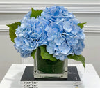 Blue hydrangea arrangement in glass vase