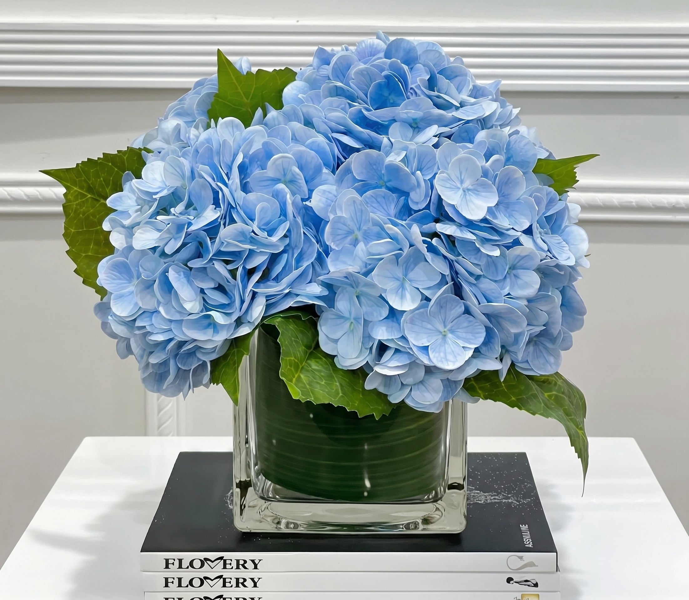 Blue hydrangea arrangement in glass vase