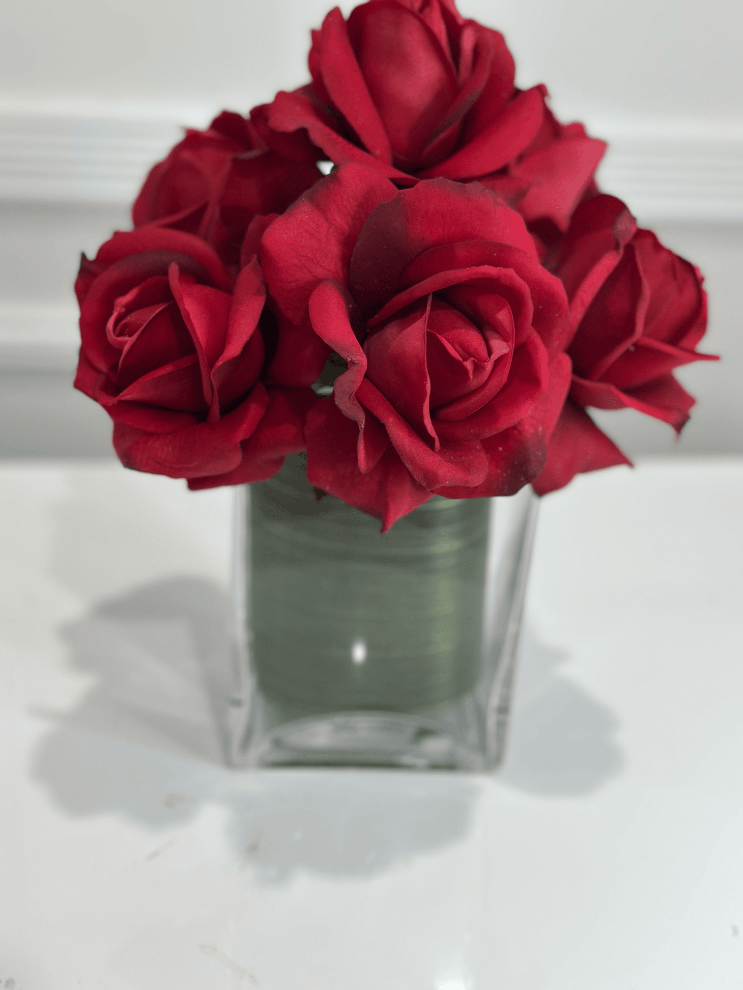 Burgundy rose arrangement in glass vase