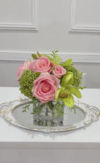 Pink and green real touch rose and orchid faux floral centerpiece in a glass vase
