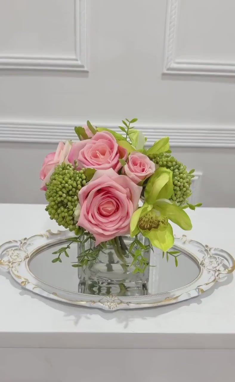 Pink and green real touch rose and orchid faux floral centerpiece in a glass vase